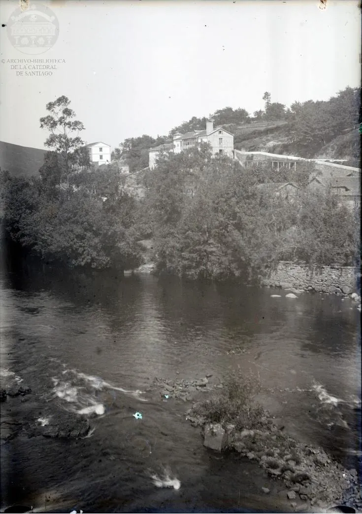 O río Tambre e as casas de pedra do Camiño de Abaixo vistos dende a ponte de Portomouro